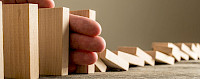 Hand die umfallende Dominosteine aufhält - © 